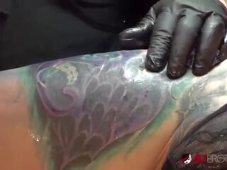 Marie bossette toques a si mesma enquanto ser tatuado